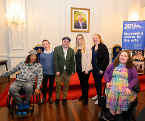 Deaf and disabled artists pose together for a group portrait in the ballroom at Government House.